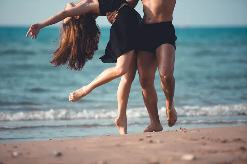 Two dancers moving together on the beach