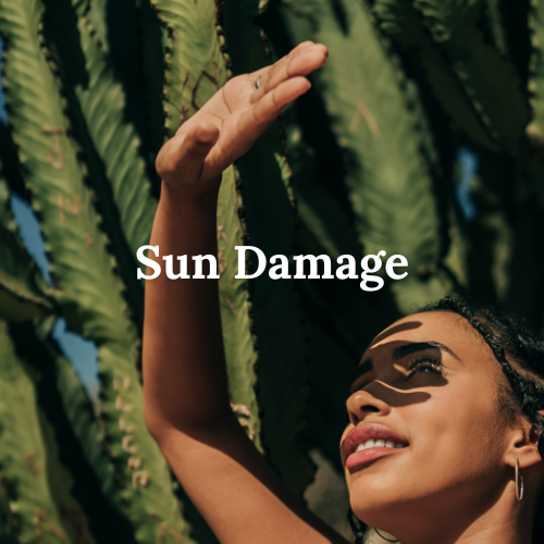 Woman raising her arm in sunlight near cactus plants, illustrating natural skincare concerns from sun exposure like discoloration or dryness.