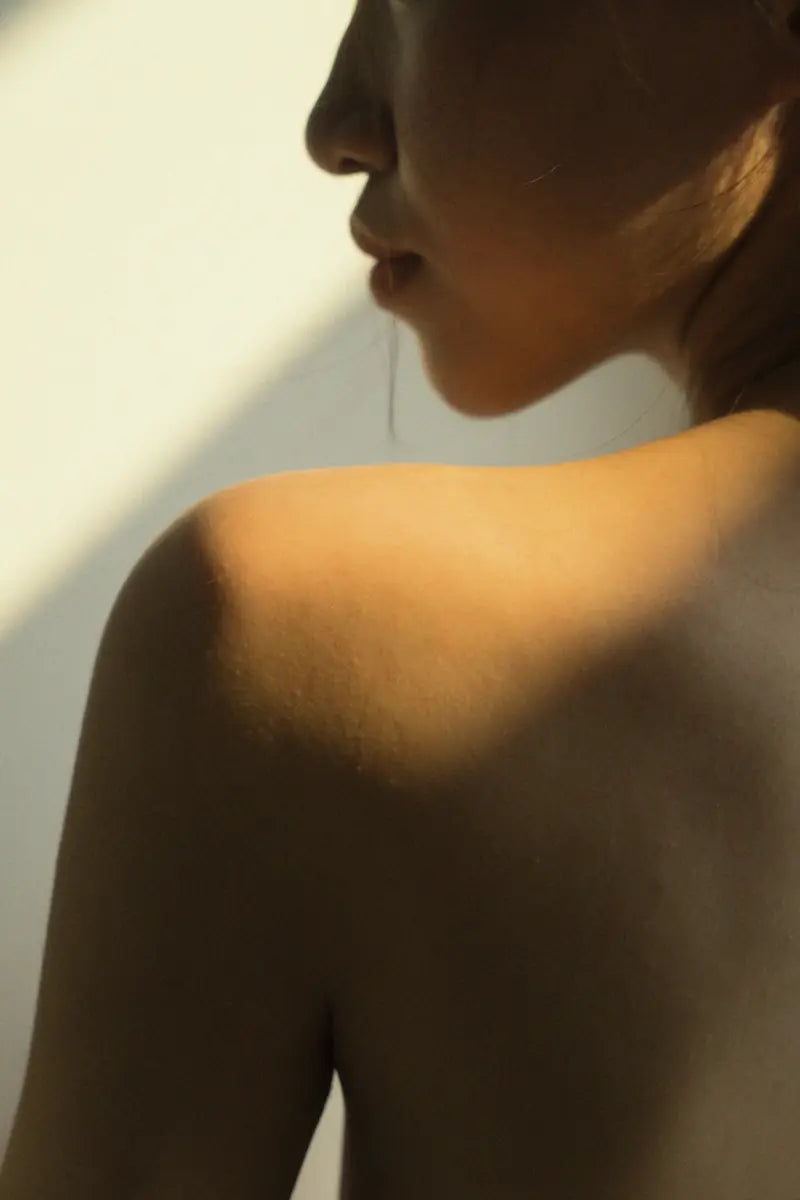 Late sun across a woman's bare shoulder