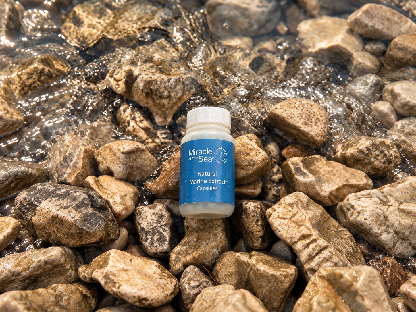 A bottle of Natural Marine Extract Capsules on wet stones as a wave washes in.