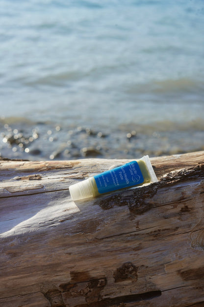 Miracle of the Sea Gum Health Paste tube on driftwood by the water